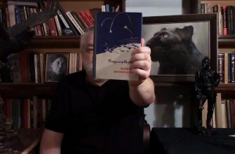 Алексей Меняйлов показывает в кадре книгу "Взять живым" Владимира Карпова